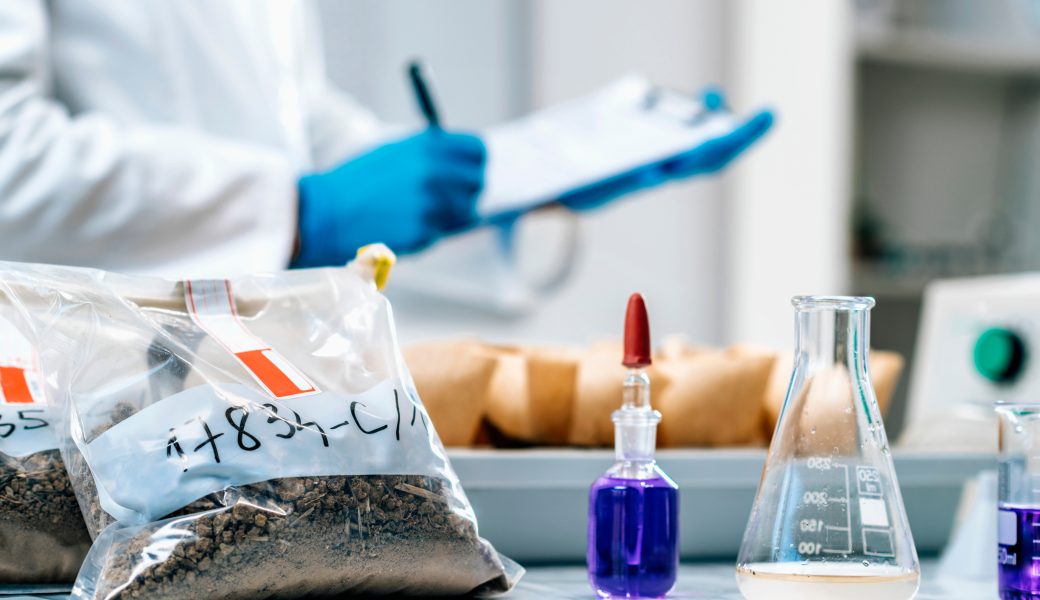 Scientist examining a bag of soil sample in the lab